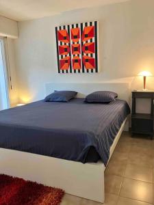 - une chambre avec un lit et une peinture murale dans l'établissement Appartements 2 chambres, grand jardin et parking, à Aix-en-Provence