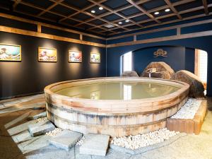 a jacuzzi tub in a blue room with paintings at 18歳以上の宿 澄江知多 in Utsumi