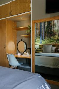 Schlafzimmer mit einem Bett, einem Schreibtisch und einem Spiegel in der Unterkunft Agapé Boutique Guesthouse Bothaville in Bothaville