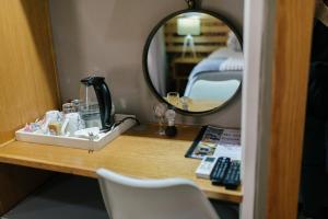 a vanity with a mirror on a table in a room at Agapé Boutique Guesthouse Bothaville in Bothaville