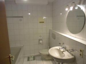 a bathroom with a sink and a toilet and a mirror at Ferienwohnung Wehr in Filderstadt