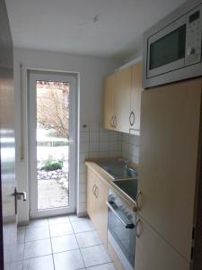 eine Küche mit einer Spüle und einer Mikrowelle in der Unterkunft Ferienwohnung Wehr in Filderstadt
