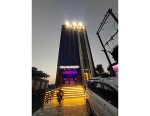 un coche aparcado frente a una torre con luces en Hotel Anuj Residency, Chitrakoot en Sītāpur Mūāfi