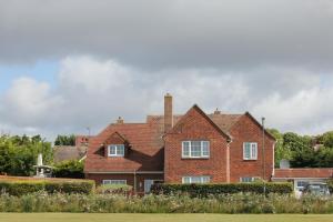 uma grande casa de tijolos vermelhos com um quintal em Goodwood Chichester, (more interior pics coming) em Tangmere