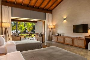 Villa Thamburu, Bentota في بينتوتا: غرفة نوم بسريرين وتلفزيون بشاشة مسطحة