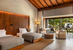 a hotel room with two beds and a patio at Villa Thamburu, Bentota in Bentota