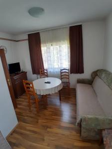 una sala de estar con una mesa y un sofá en Guest house Kolasin, en Kolašin