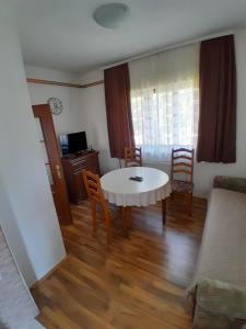 Una sala de estar con una mesa y sillas blancas. en Guest house Kolasin, en Kolašin
