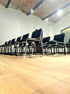 een rij stoelen in een kamer met houten vloeren bij Hotel Bohemian Garni - Skadarlija in Belgrado