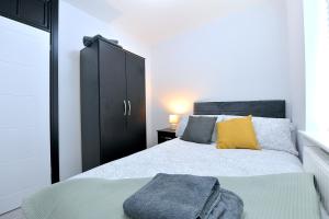 a bedroom with a bed and a black cabinet at North West London Escape in Mill Hill