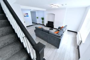a living room with a couch and a staircase at North West London Escape in Mill Hill