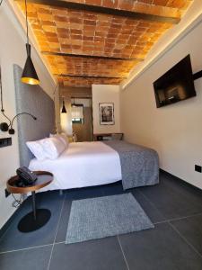 a bedroom with a large white bed and a table at Hotel El Rosal de Cudillero in Cudillero