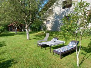 two benches and a table in a yard at Peaceful Oasis - house for rest and relaxation in Bosanska Krupa