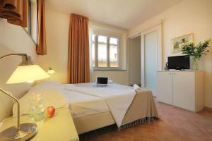 1 dormitorio con 1 cama con ordenador portátil en Relais White Houses Florence, en Florencia