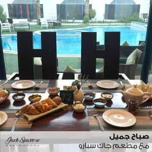 Majestic Hotel في المنامة: طاولة عليها طعام امام المسبح