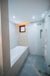 een witte badkamer met een bad en een douche bij KLM Condotel in Angeles