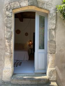 an open door into a bedroom with a bed at Maison Tara verte au Mas Montredon in Arles