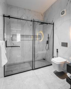 uma casa de banho com uma cabina de duche em vidro e um WC. em DLUXE PREMIUM HOTEL em Port Harcourt
