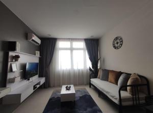 a living room with a couch and a tv at Senandika Homestay in Kuching
