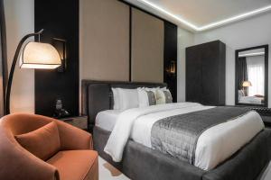 ポートハーコートにあるDLUXE PREMIUM HOTELのベッドと椅子付きのホテルルーム