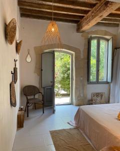 sypialnia z łóżkiem, krzesłem i oknem w obiekcie Maison Tara verte au Mas Montredon w mieście Arles