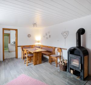 a living room with a wood stove and a table at 4 Bett Ferienwohnung Lavendel in Wengenroth