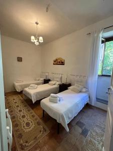 a room with three beds and a chandelier at A un passo dal castello in Pacentro