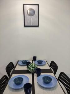 a table with blue dishes on it with chairs at Senandika Homestay in Kuching