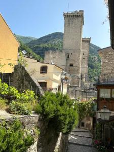 an old building with a tower in a town at A un passo dal castello in Pacentro