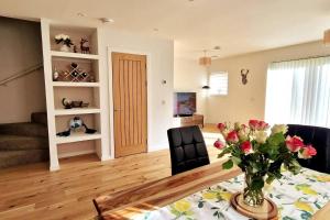 una sala de estar con una mesa con un jarrón de flores en Luxury 3-Bed House in the Scottish Highlands en Inverness