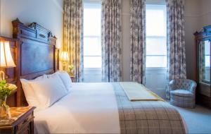 a bedroom with a large bed and a window at The Falcon Hotel in Uppingham