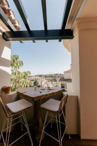 a table and chairs on a balcony with a view at Capanes de Golf Luxury Apt in Benahavís