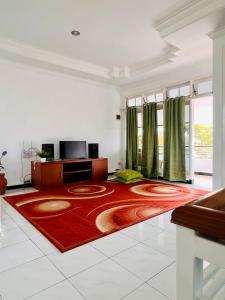 Villa Dedaun Batu في باتو: غرفة معيشة مع سجادة حمراء على الأرض