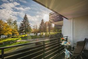 a balcony with a table and chairs looking out onto a street at Sporthotel Grafenwald in Daun