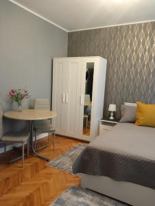 a bedroom with a bed and a table and a desk at Crystal Room in Timişoara