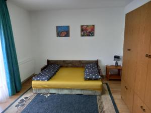 a bedroom with a yellow bed in a room at Peaceful Oasis - house for rest and relaxation in Bosanska Krupa