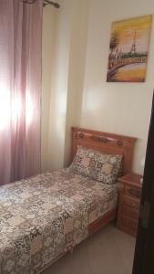 1 dormitorio con 1 cama y una foto en la pared en Appart ElCampo, en Tánger