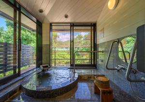 a bathroom with a large tub in the middle at Kawatana Grand Hotel Otafuku in Shimonoseki