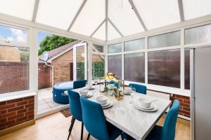 a dining room with a table and blue chairs at Sleek Stylish House 2 Parking - Hot tub in Bristol +29 photos