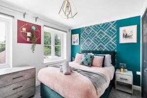 una camera con letto e pareti blu di Sleek Stylish House 2 Parking - Hot tub & Arcade a Bristol