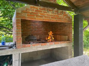 um forno de tijolos com um fogo dentro dele em Peaceful Oasis - house for rest and relaxation em Bosanska Krupa