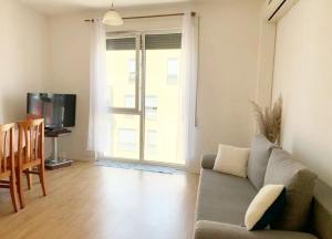 Beautiful and lovely apartment في تيرانا: غرفة معيشة بها أريكة وتلفزيون