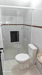 a white bathroom with a toilet and a shower at SUITE STAR in Pau dos Ferros