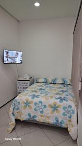 a bedroom with a bed with a floral bedspread at SUITE STAR in Pau dos Ferros