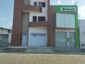 a building with two garage doors and a sign on it at SUITE STAR in Pau dos Ferros +2 photos