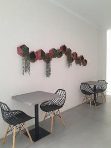 two tables and chairs with christmas decorations on a wall at Uresidence Bengkulu in Bengkulu
