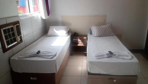 2 Betten in einem Zimmer mit Handtüchern darauf in der Unterkunft Hotel Orquídea -Rudge Ramos (Adults only) in São Bernardo do Campo