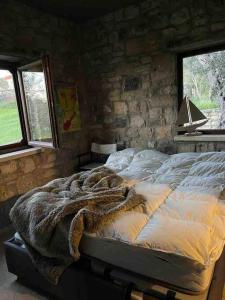 a bed in a room with a stone wall at Tepeboz Stone House Tuscany in Karaburun in Karaburun