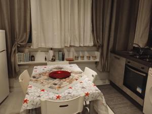 una cocina con una mesa con una placa roja. en Il Sole e la Luna - Apartment, en Montesilvano 13 fotos más