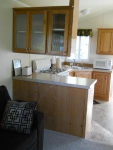 Willow Bay RV Resort & Marina في Nine Mile Falls: مطبخ مع خزائن خشبية وطاولة عمل
